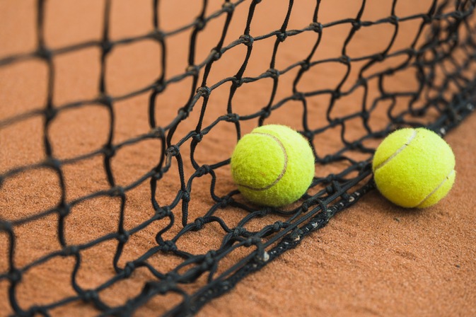 two-tennis-ball-near-black-net-ground.jpg